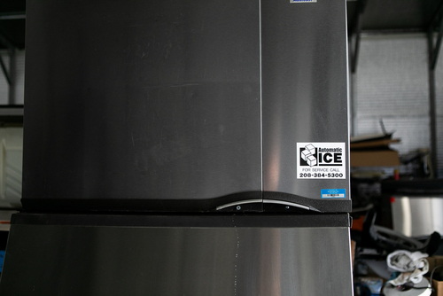 Large ice machine with company phone number printed on its front